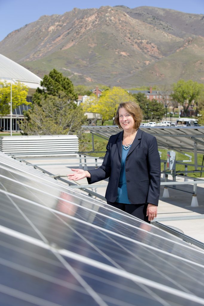 Ruth Watkins stands with campus solar panel.